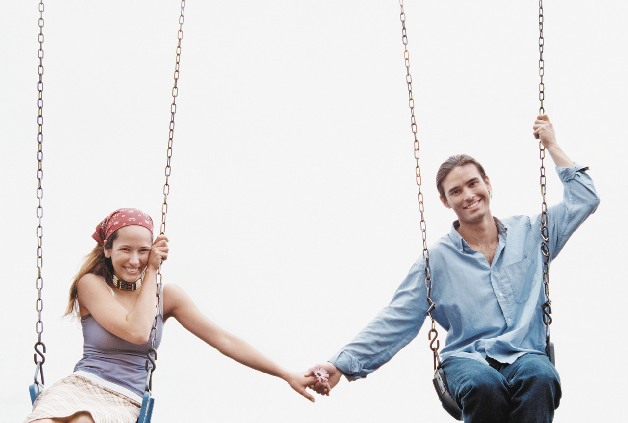 Couple Holding Hands on Swing Set